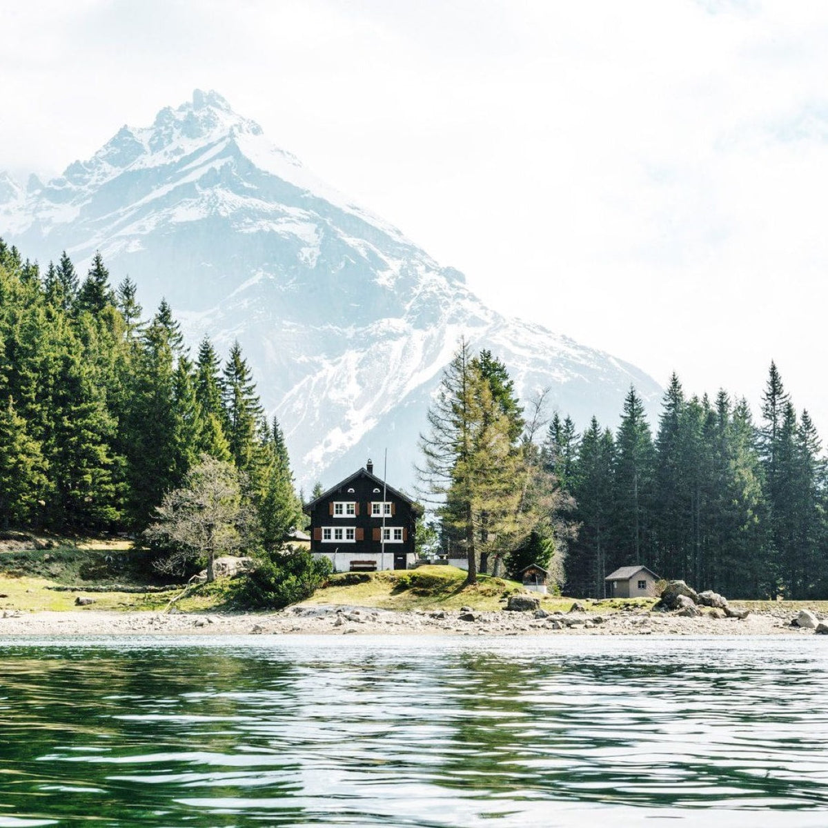 An alpine chalet beneath a snowy peak in Switzerland.