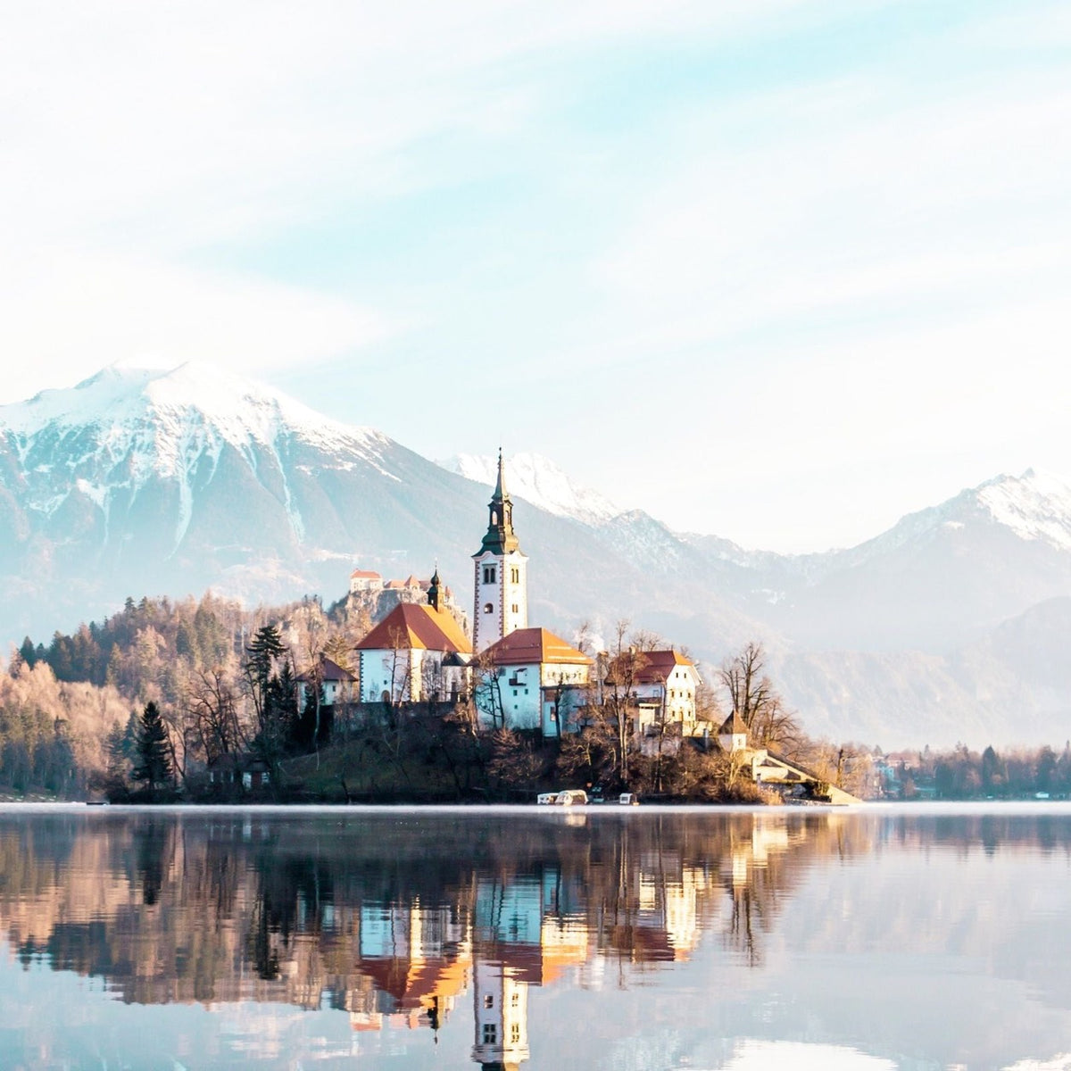 A lakeside church beneath Alpine peaks in Slovenia.